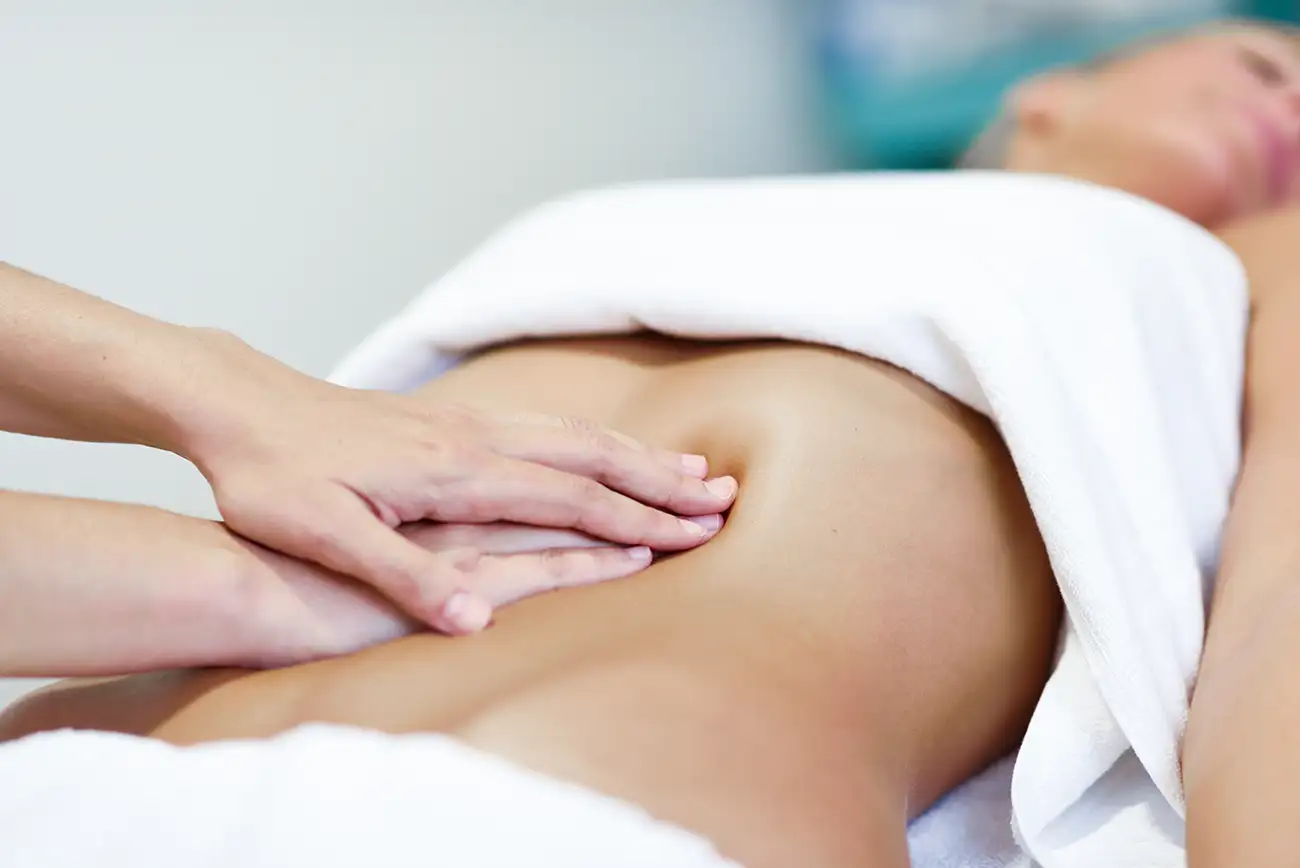 Pavimento Pelvico_hands-massaging-female-abdomen-therapist-applying-pressure-on-belly